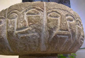 Twelfth century font with carved faces.