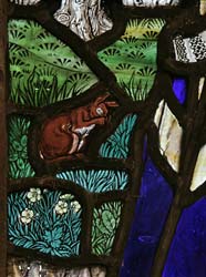 Detail of stained glass by Florence Camm showing squirrel, flowers and grasses.
